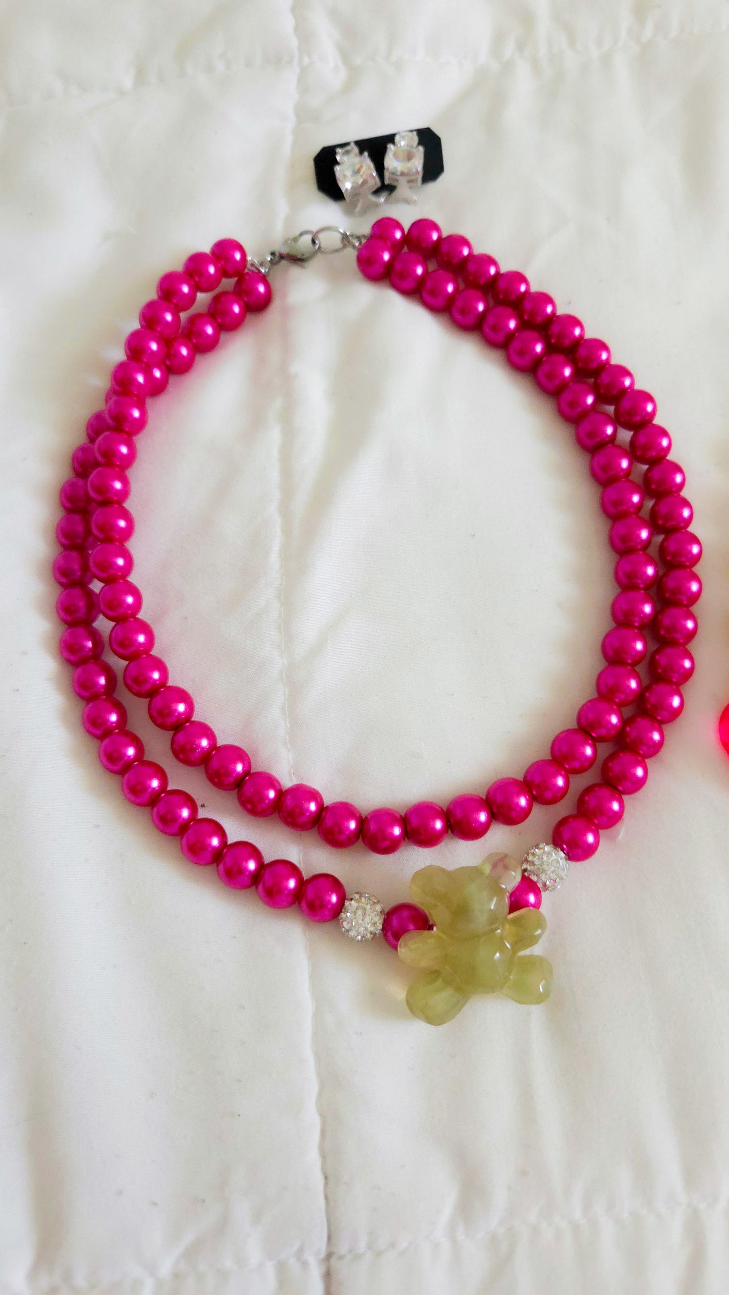 Chunky layered necklace with fuchsia glass pearls, rhinestone beads, and an acrylic olive green teddy bear charm β Y2K dopamine dressing statement jewelry by Lalabel.