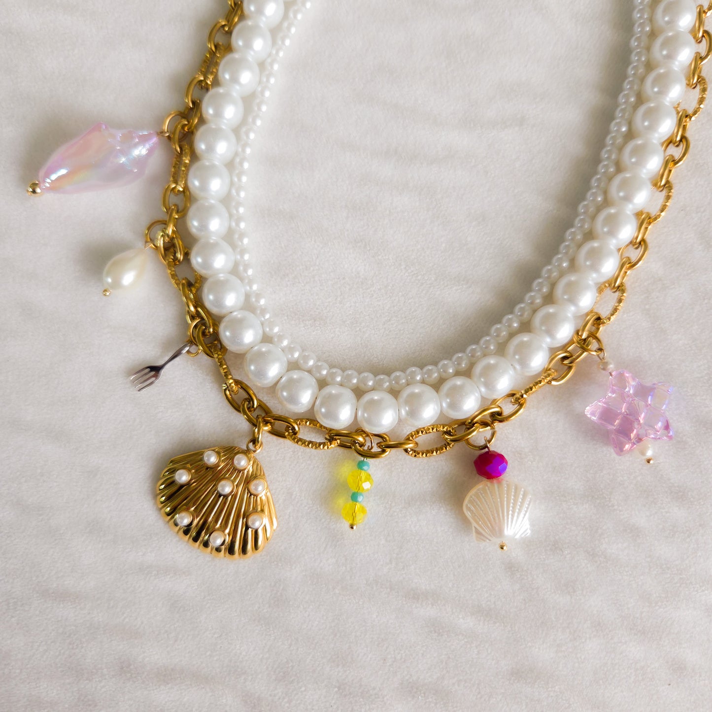 Three-layer Ariel-inspired necklace with glass pearls, gold-plated ocean-themed charms, and stainless steel chain. Handmade Disney princess jewelry.
