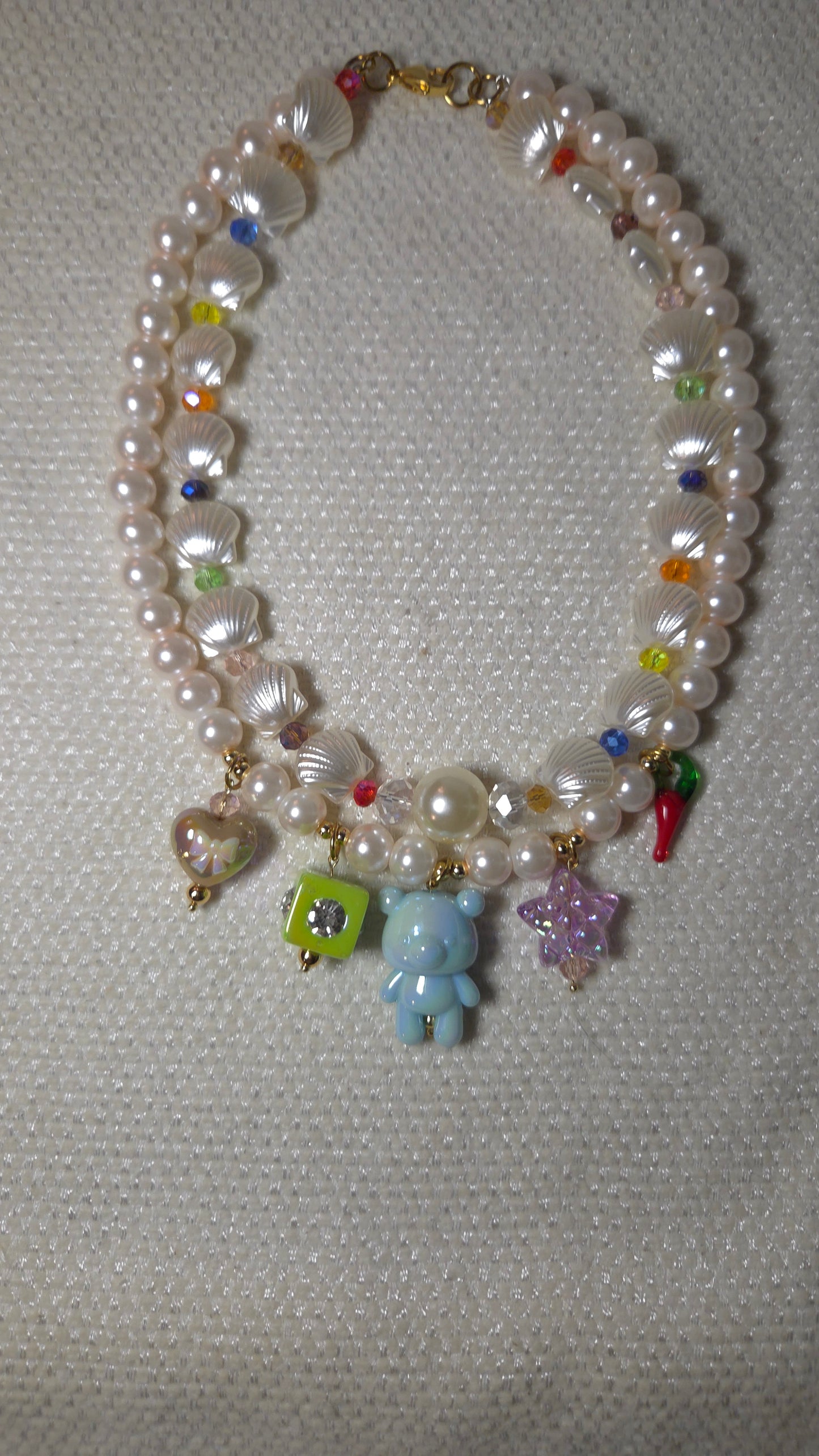 Mermaid Charms Dream Necklace con perlas de cristal, conchitas acrílicas, cristales facetados y charms colgantes de osito, estrella, corazón y pepper charm. Diseño maximalista dopamine dressing Lalabel.