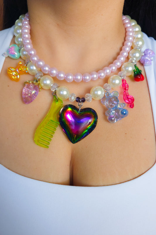 Layered necklace with pink glass pearls, chunky acrylic pearls, AB crystals, and assorted kawaii charms including a neon comb, teddy, cherry, and iridescent heart – Y2K dopamine dressing jewelry by Lalabel.

