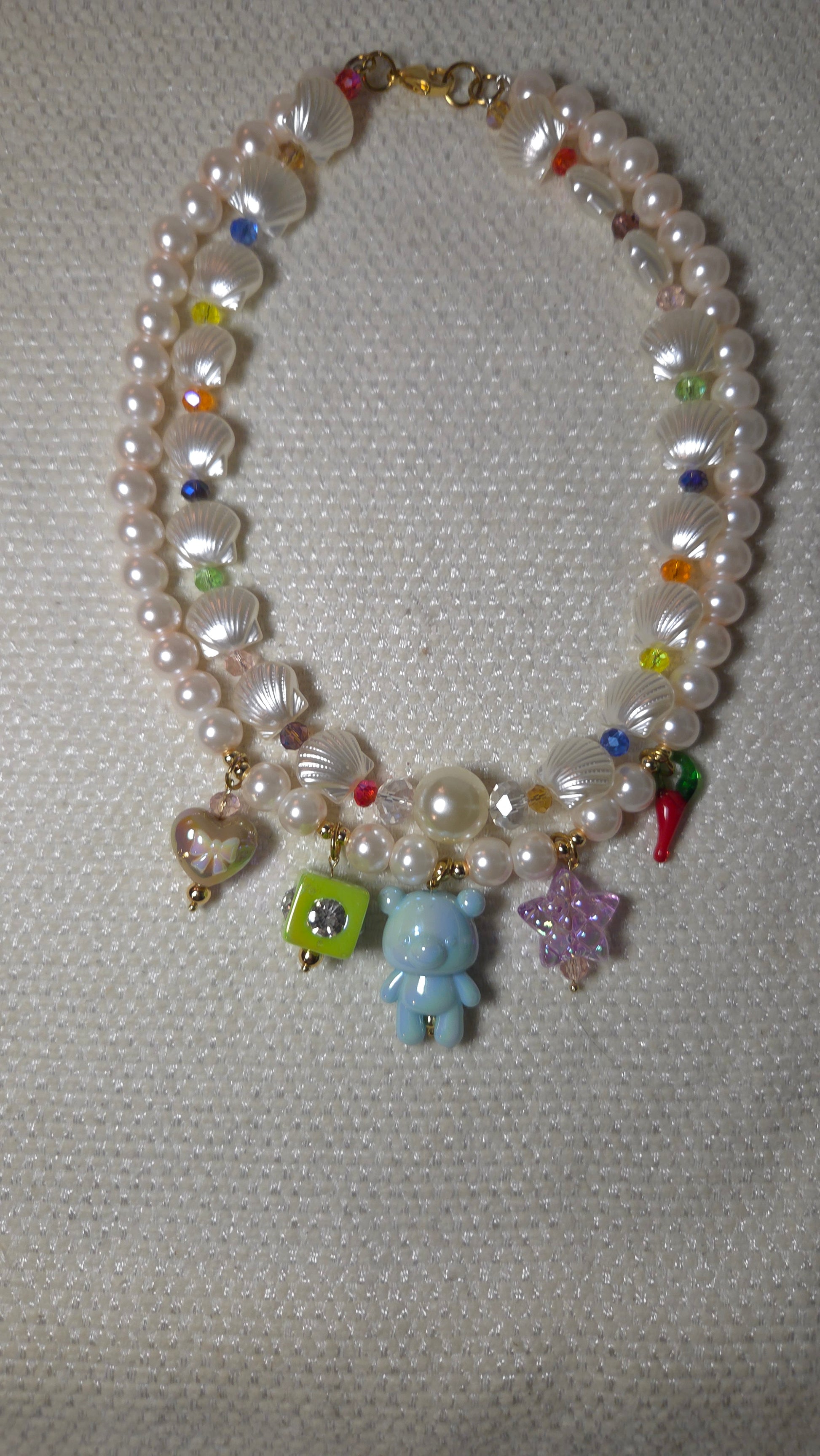 Mermaid Charms Dream Necklace con perlas de cristal, conchitas acrílicas, cristales facetados y charms colgantes de osito, estrella, corazón y pepper charm. Diseño maximalista dopamine dressing Lalabel.